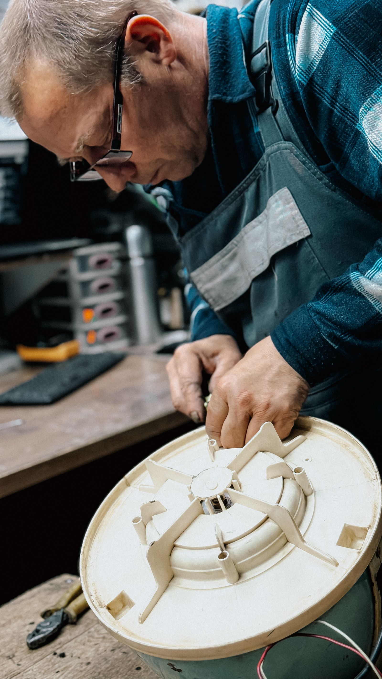 Senior technician repairing home appliance part