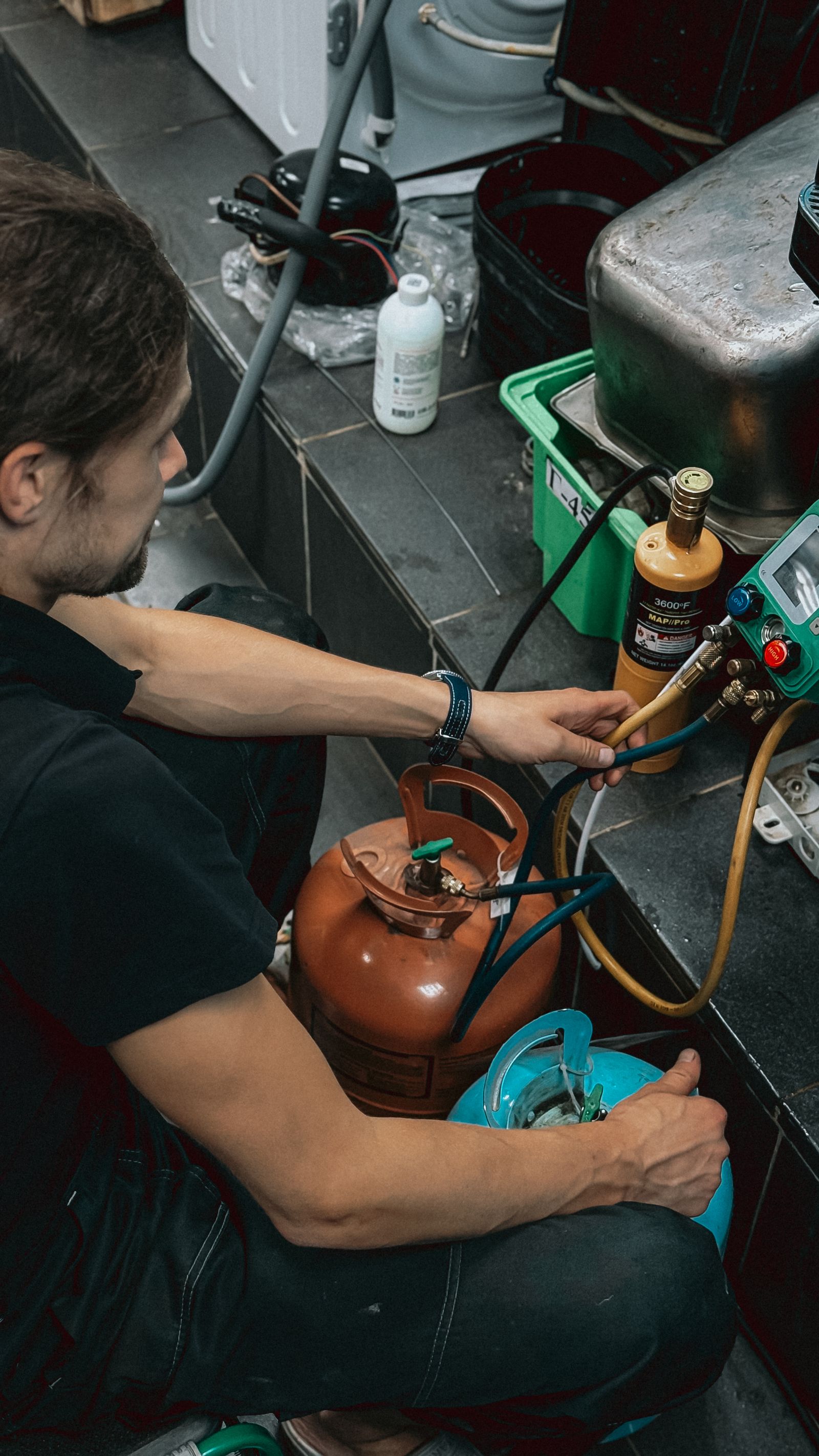 Technician handling refrigerant in workshop setting