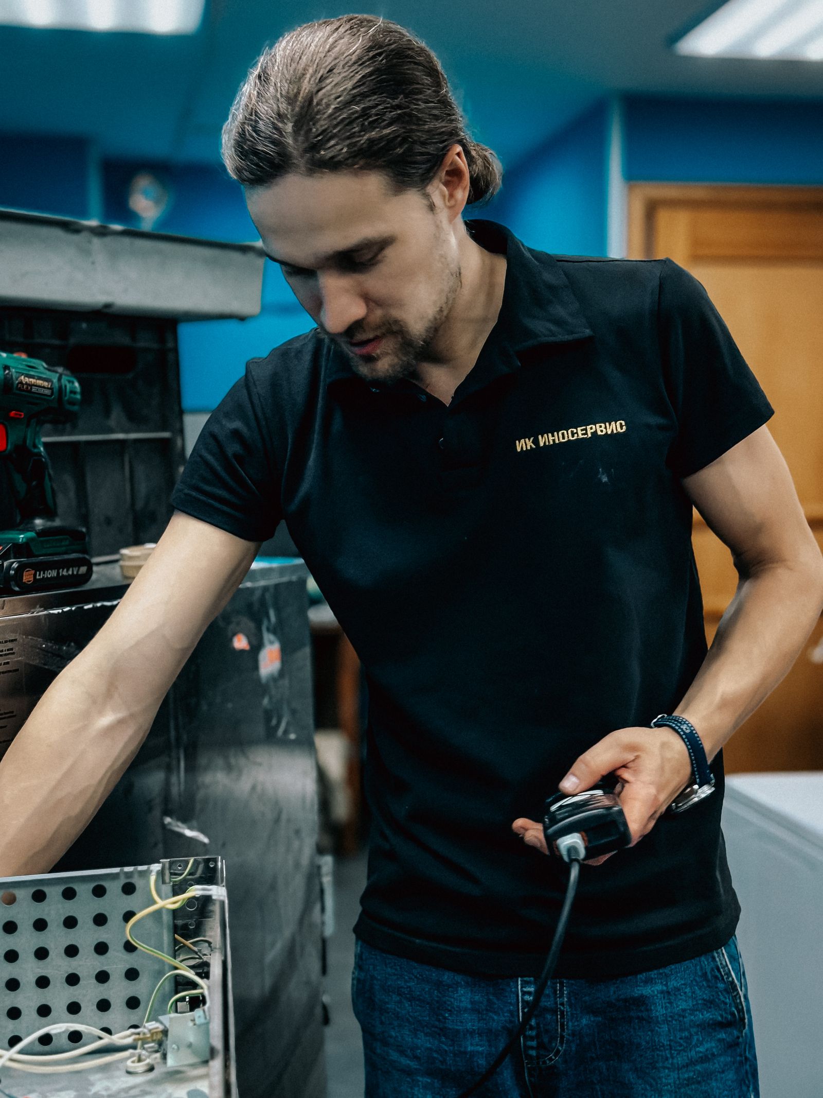 Technician repairing kitchen equipment in workshop