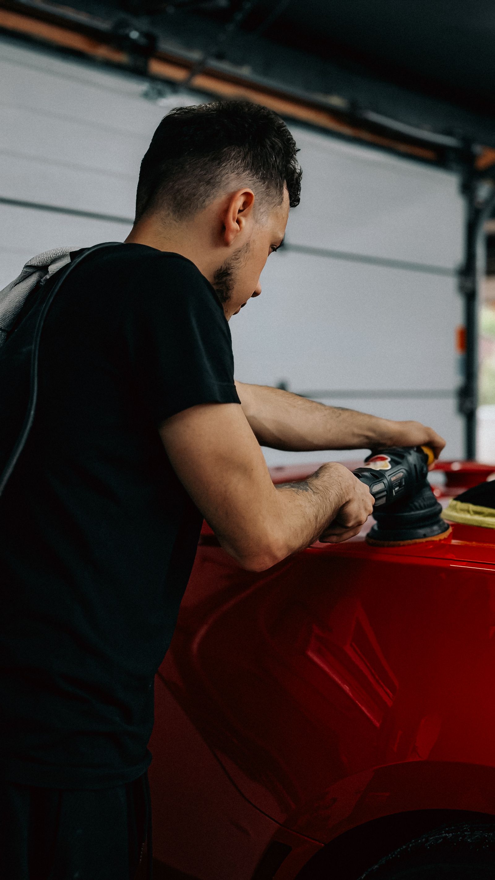 Smiling mechanic working on a vehicle in garage