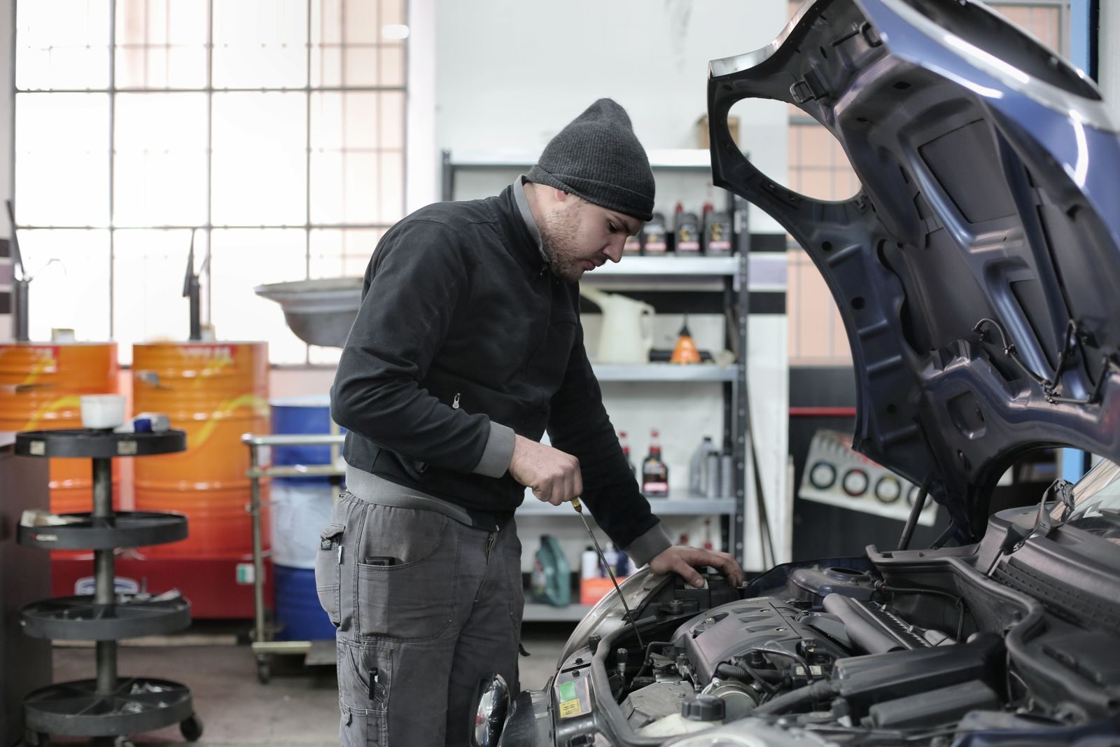 Mechanic checking a car engine in a garage, ensuring quality maintenance and repair