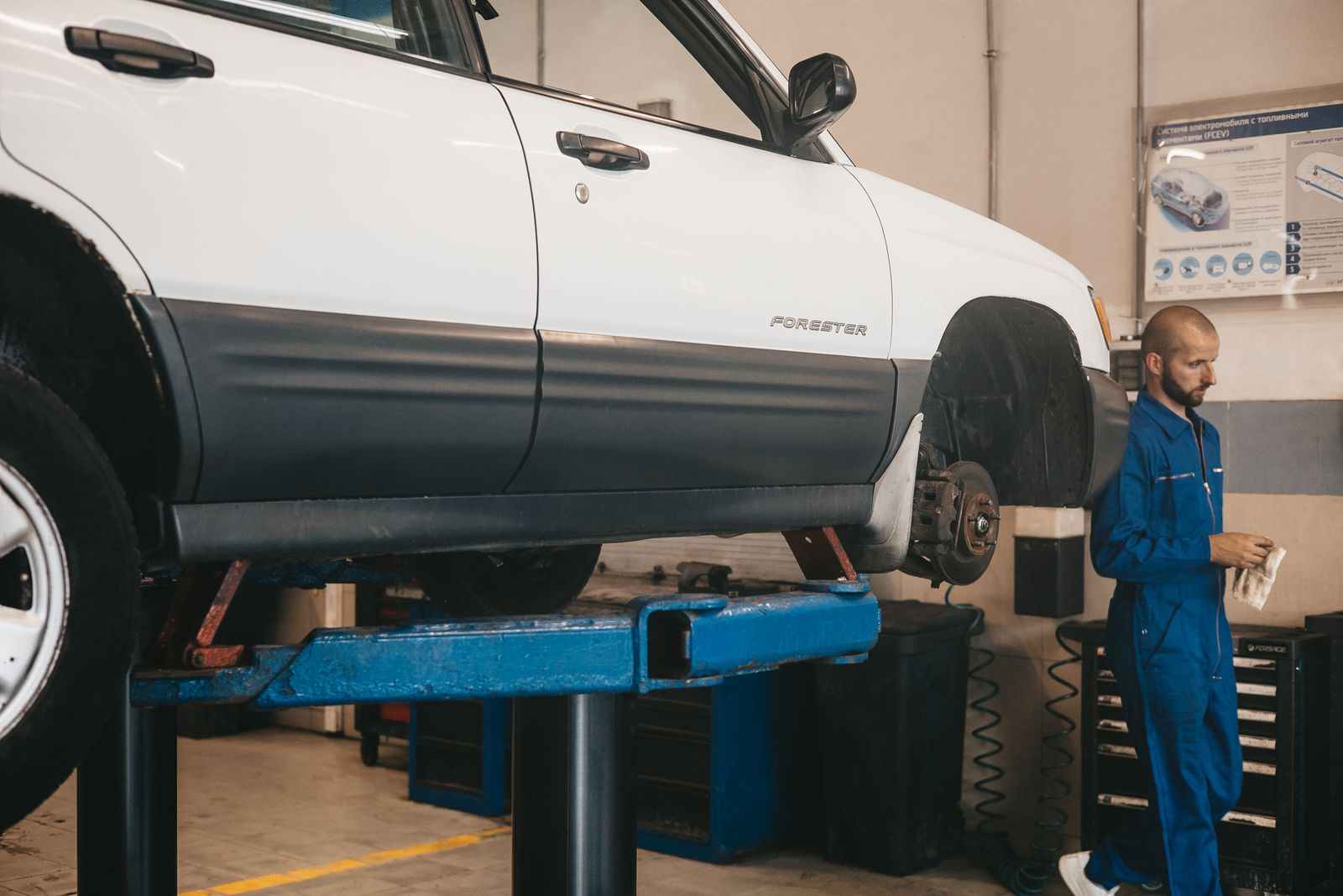 Auto mechanic with customer at car