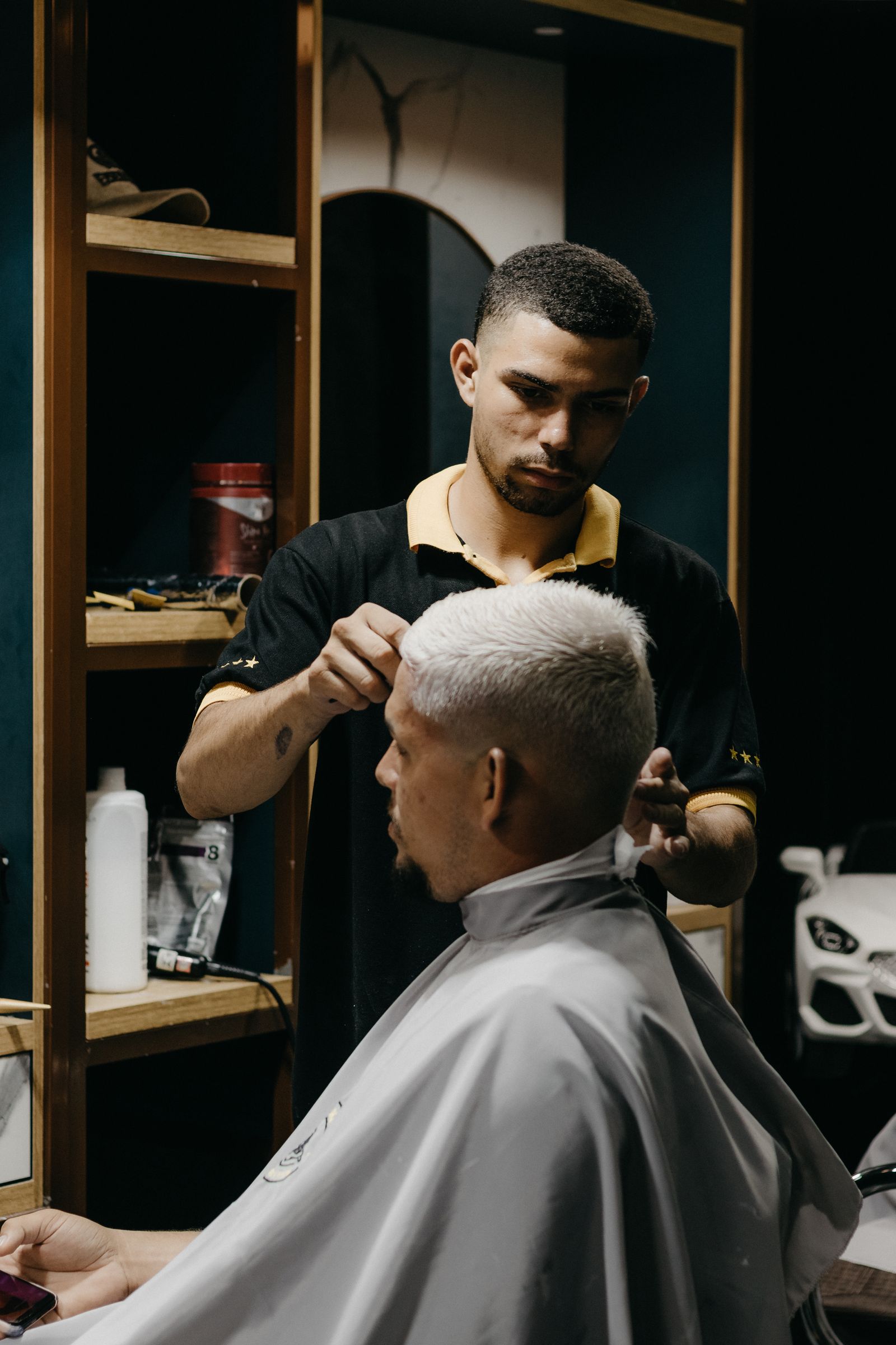 Client sitting by barber in salon