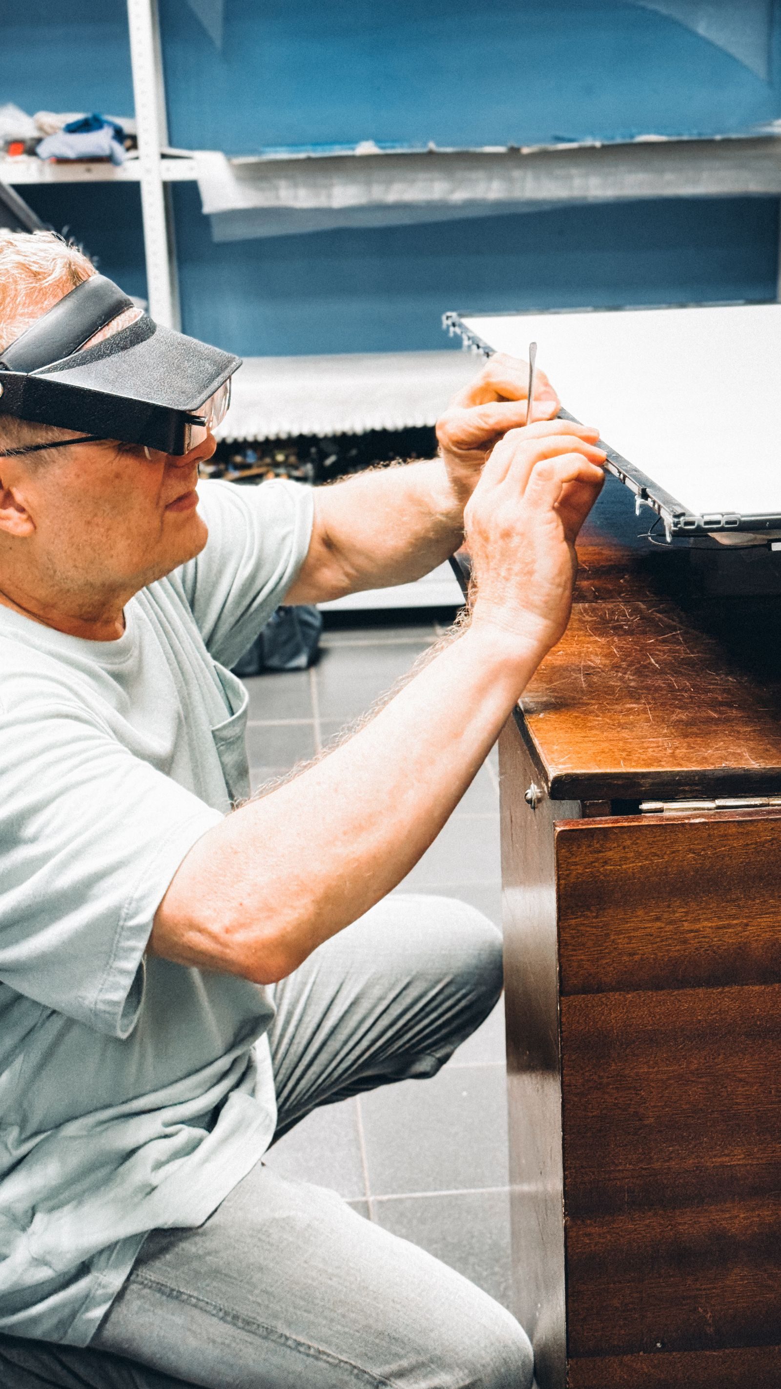 A focused technician uses tools to fix electronic device parts