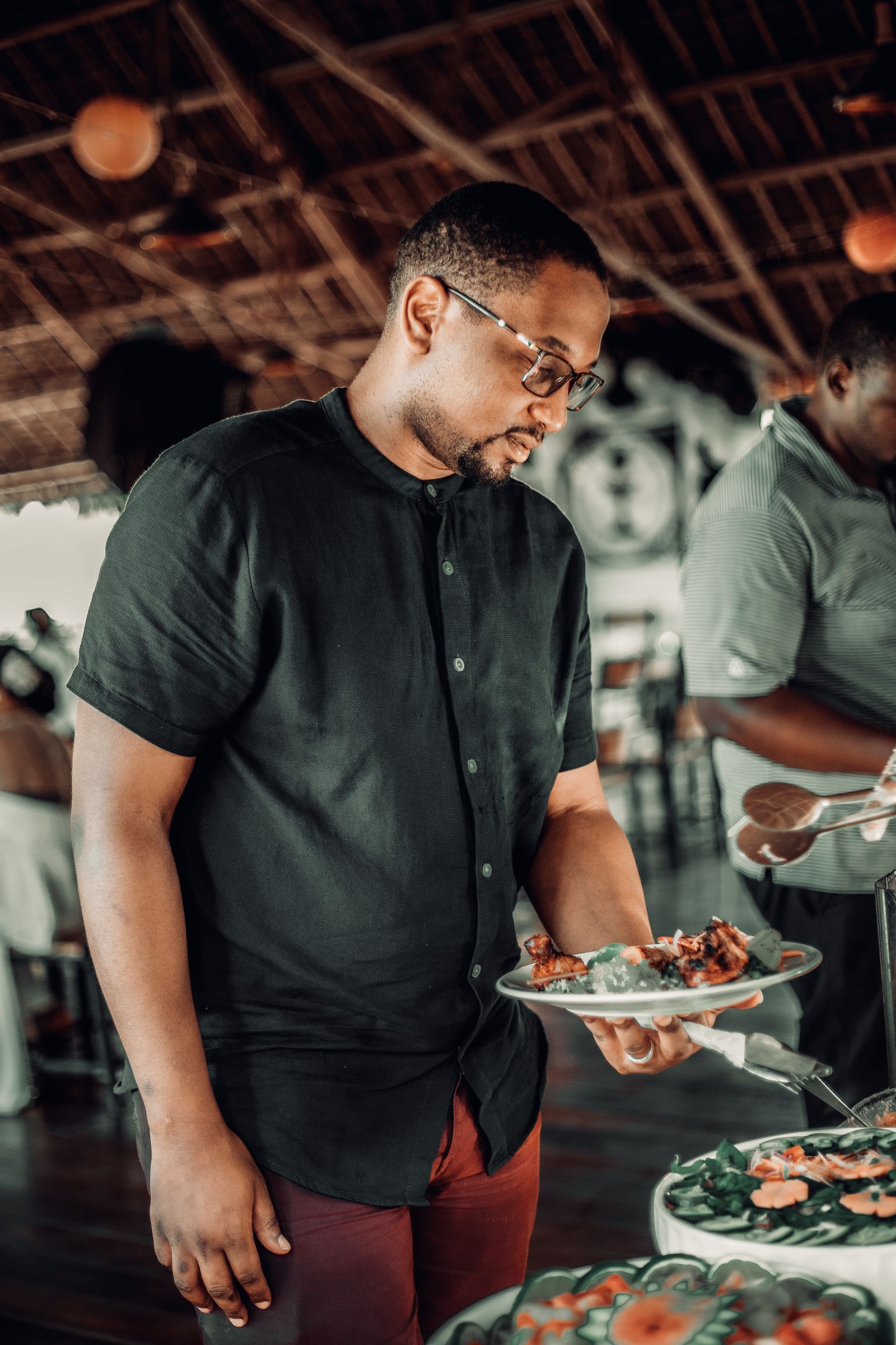 Man holding a plate with food at a reception