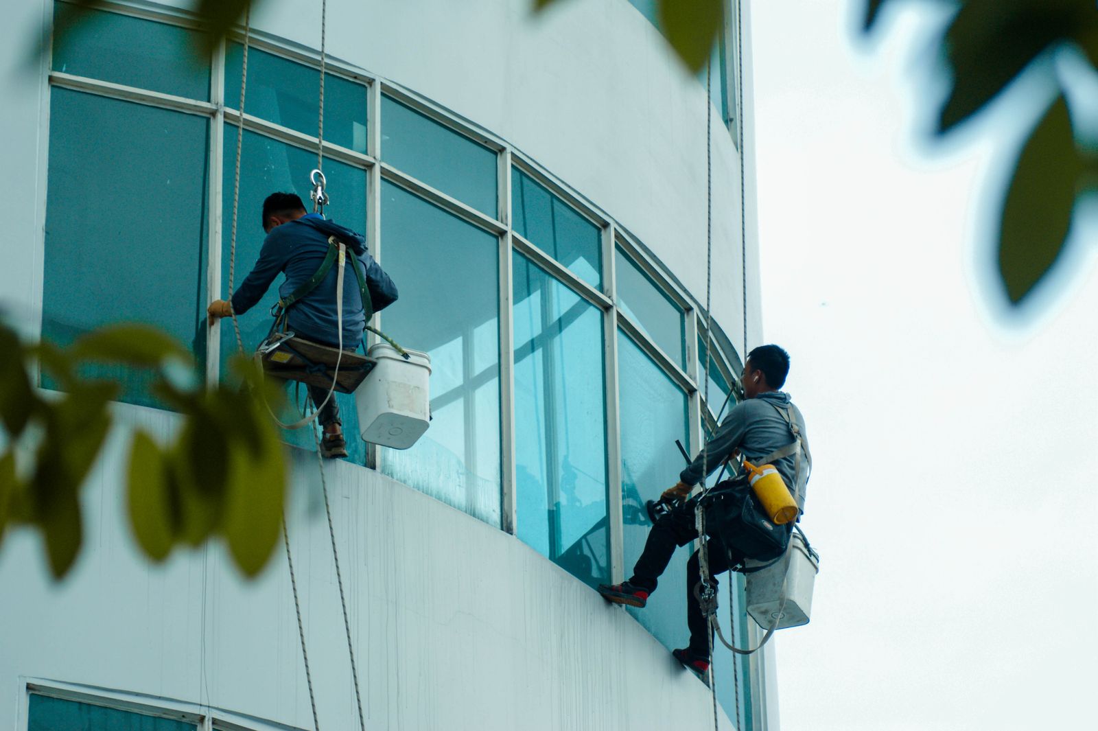 Workers cleaning high rise windows via suspended access