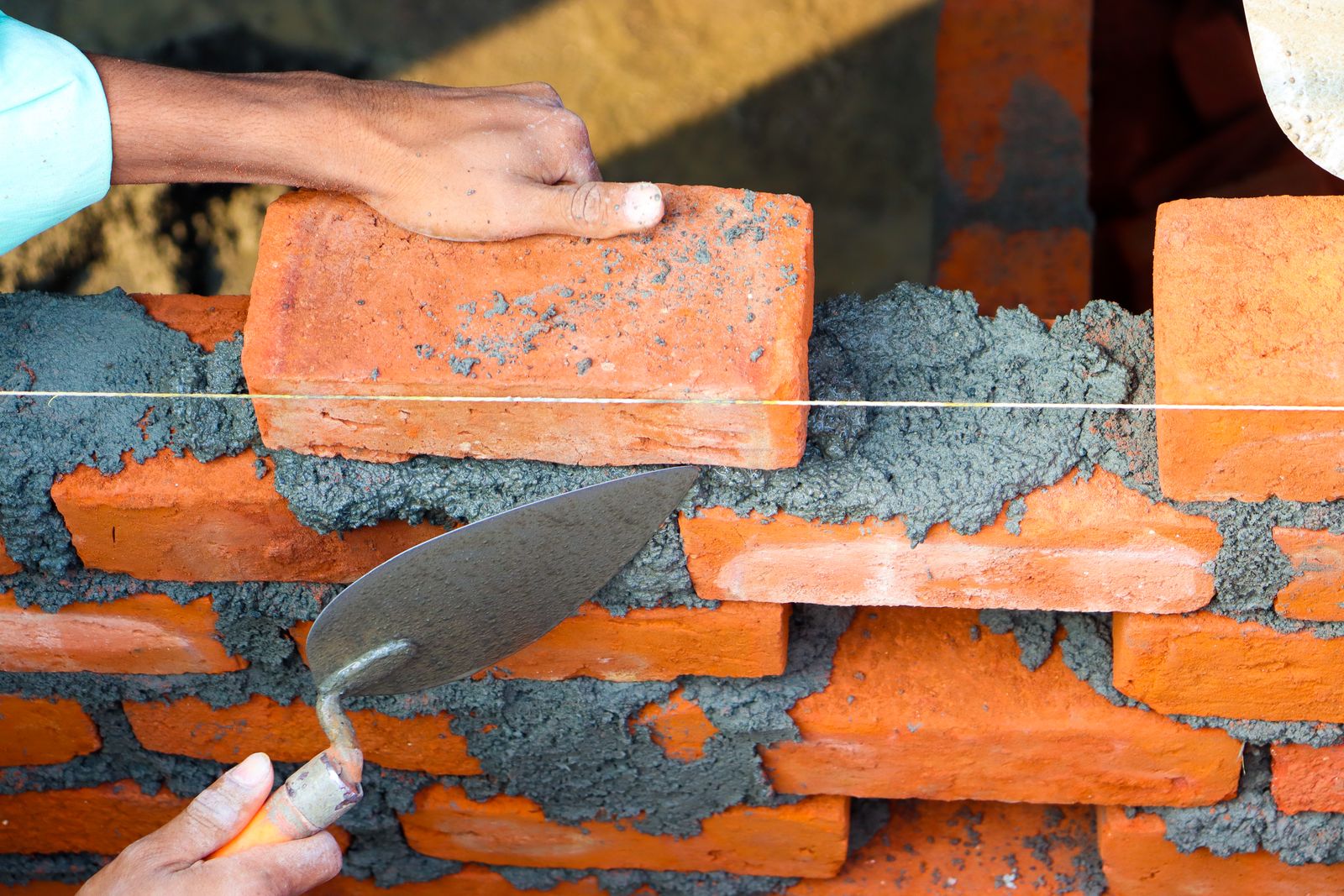 Close up of man building bricks wall