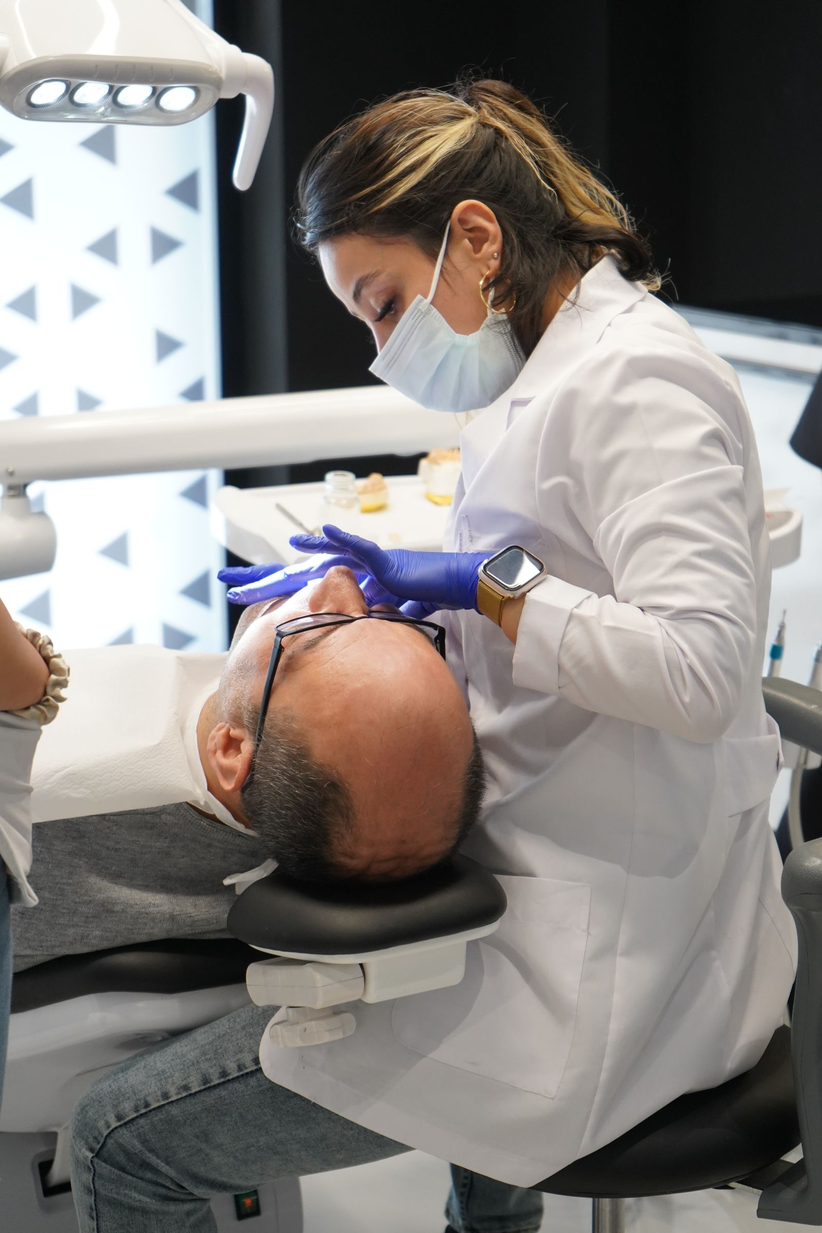 Dentist sitting and working on patient