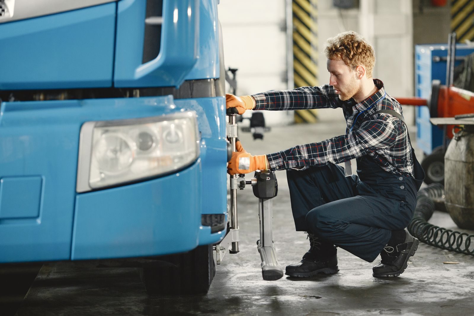 A male mechanic is aligning truck tires in a professional workshop setting