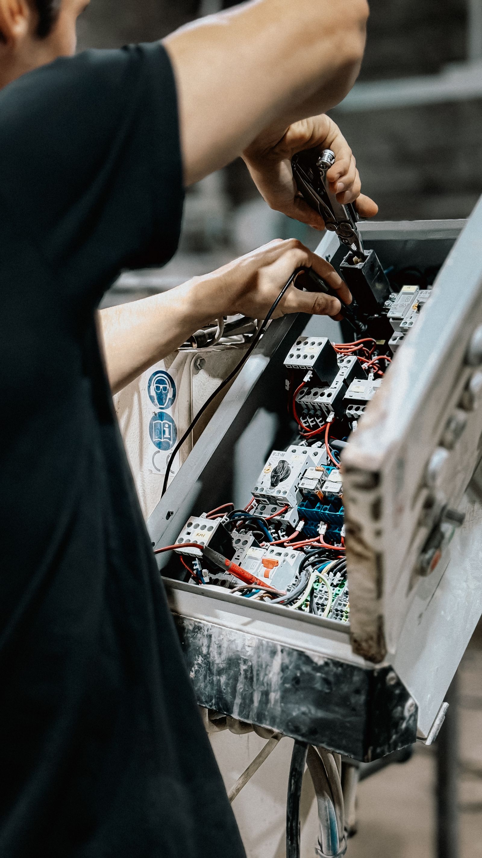 Technician working on electrical control panel