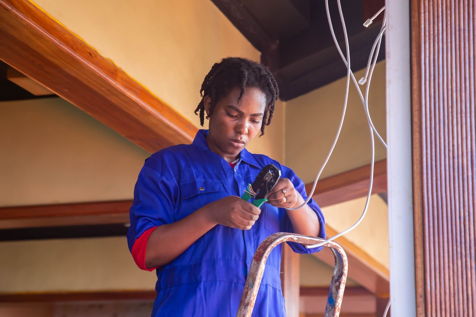 Professional electrician working on wiring in an indoor setting, demonstrating skill and concentration