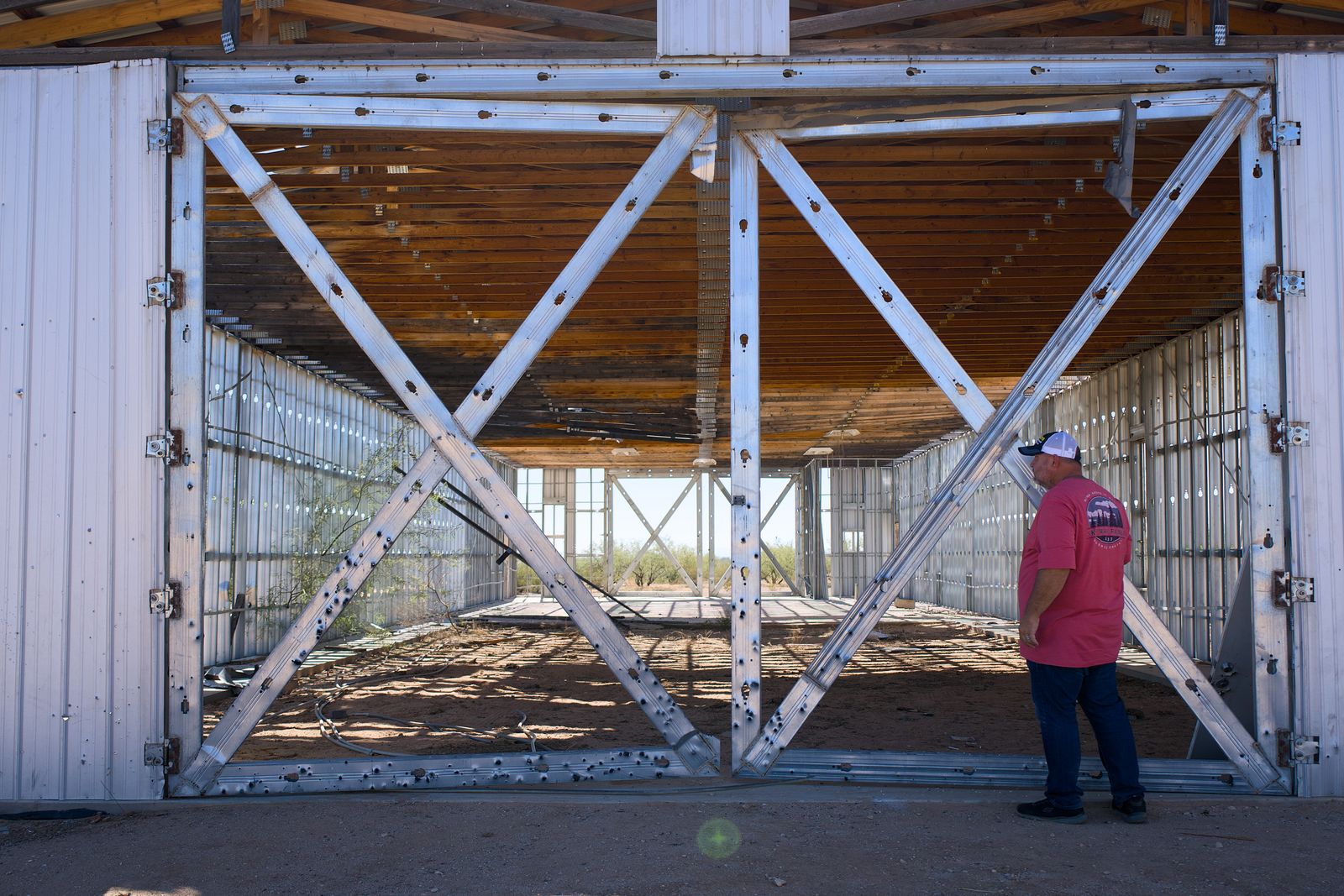Man inspects large metal structure on sunny day