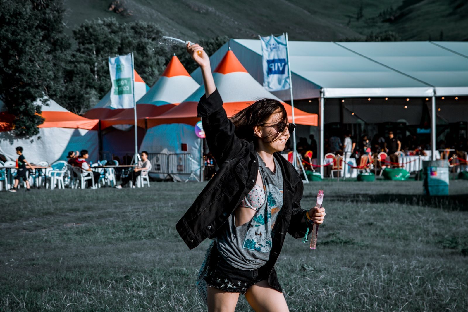 A woman joyfully plays with bubbles at an outdoor festival