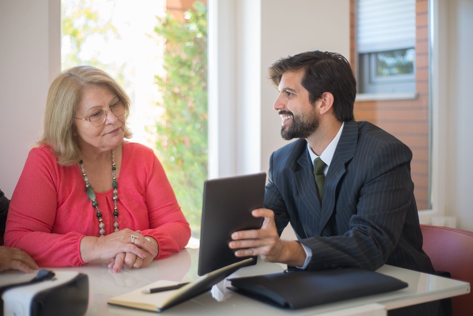 Elderly woman consulting with a realtor about a property deal in a cozy indoor setting