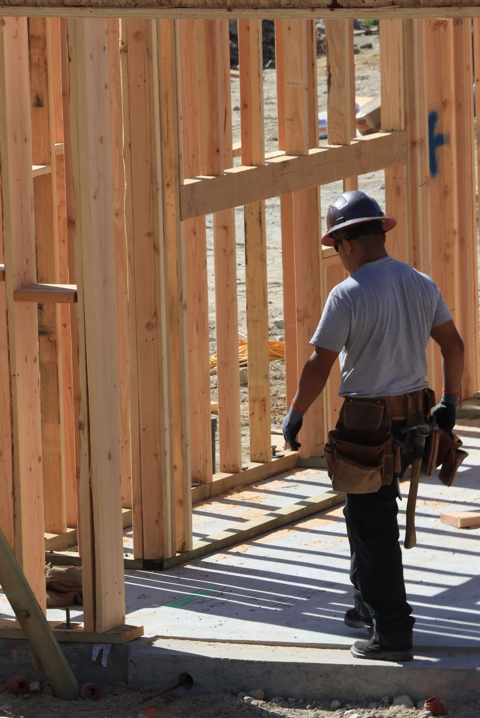 Construction worker on site building wooden frame home during the day