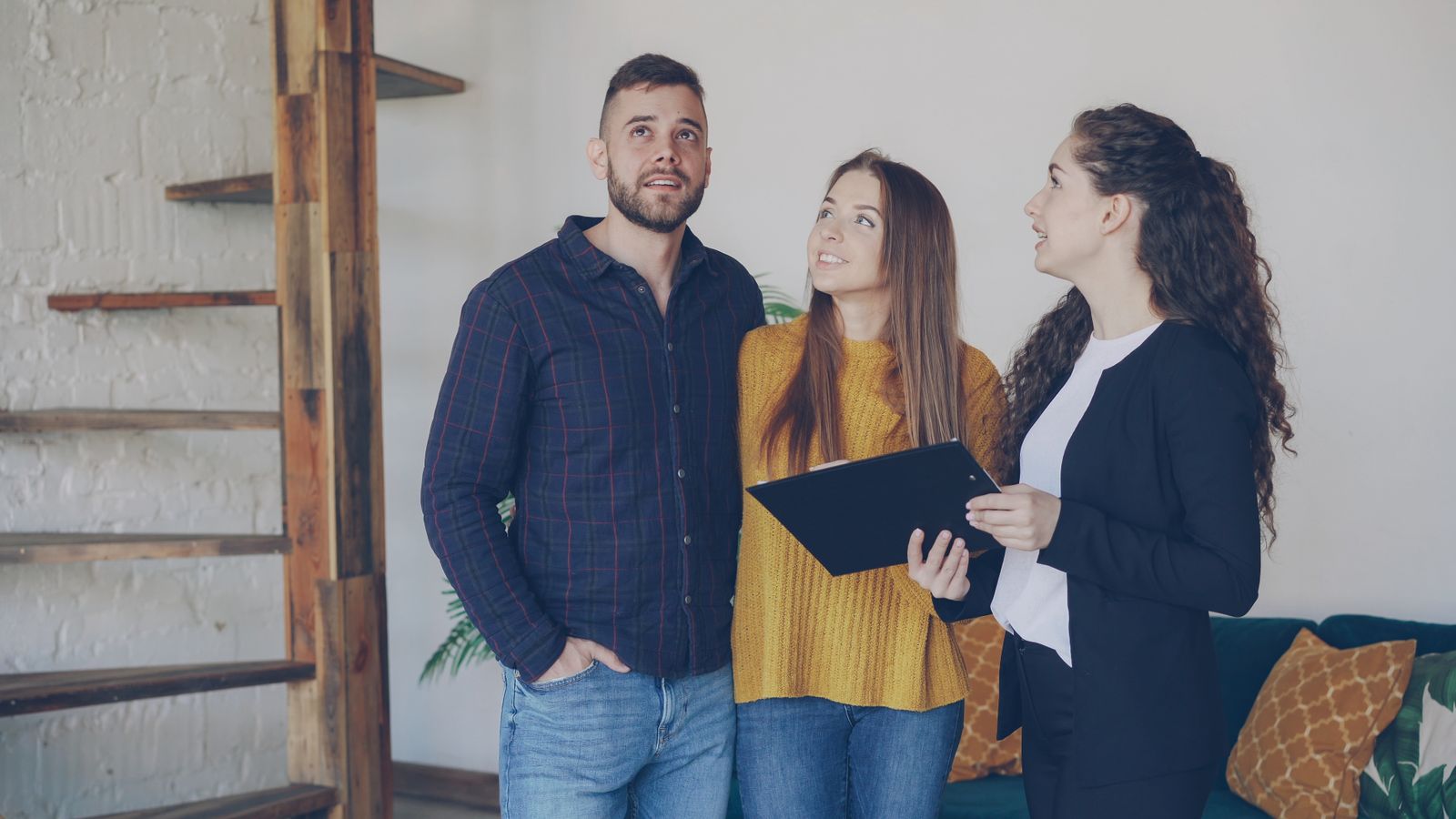 Young couple viewing home with real estate agent