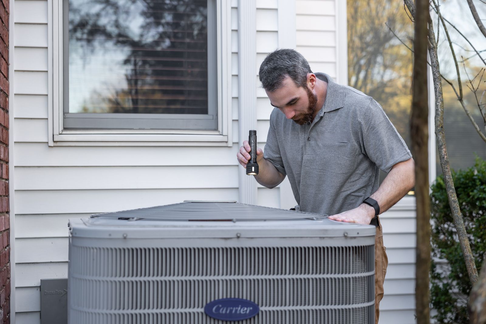 Technician inspecting outdoor hvac unit