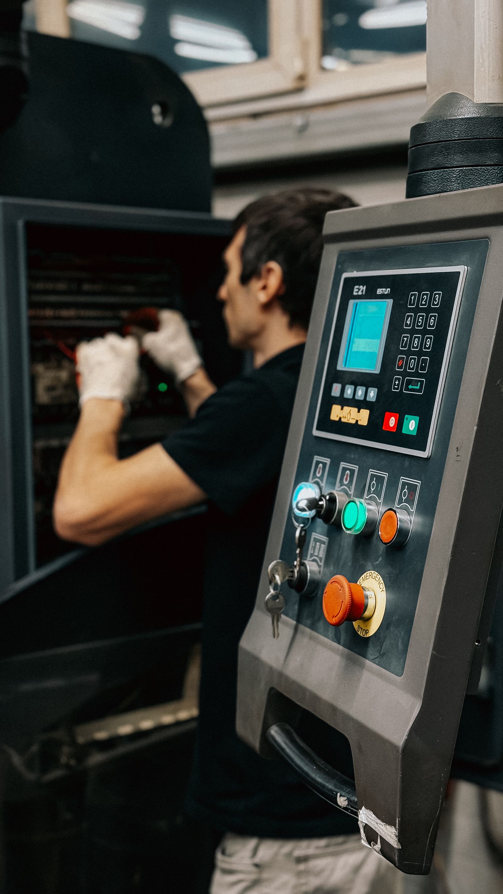 Industrial worker operating machinery control panel