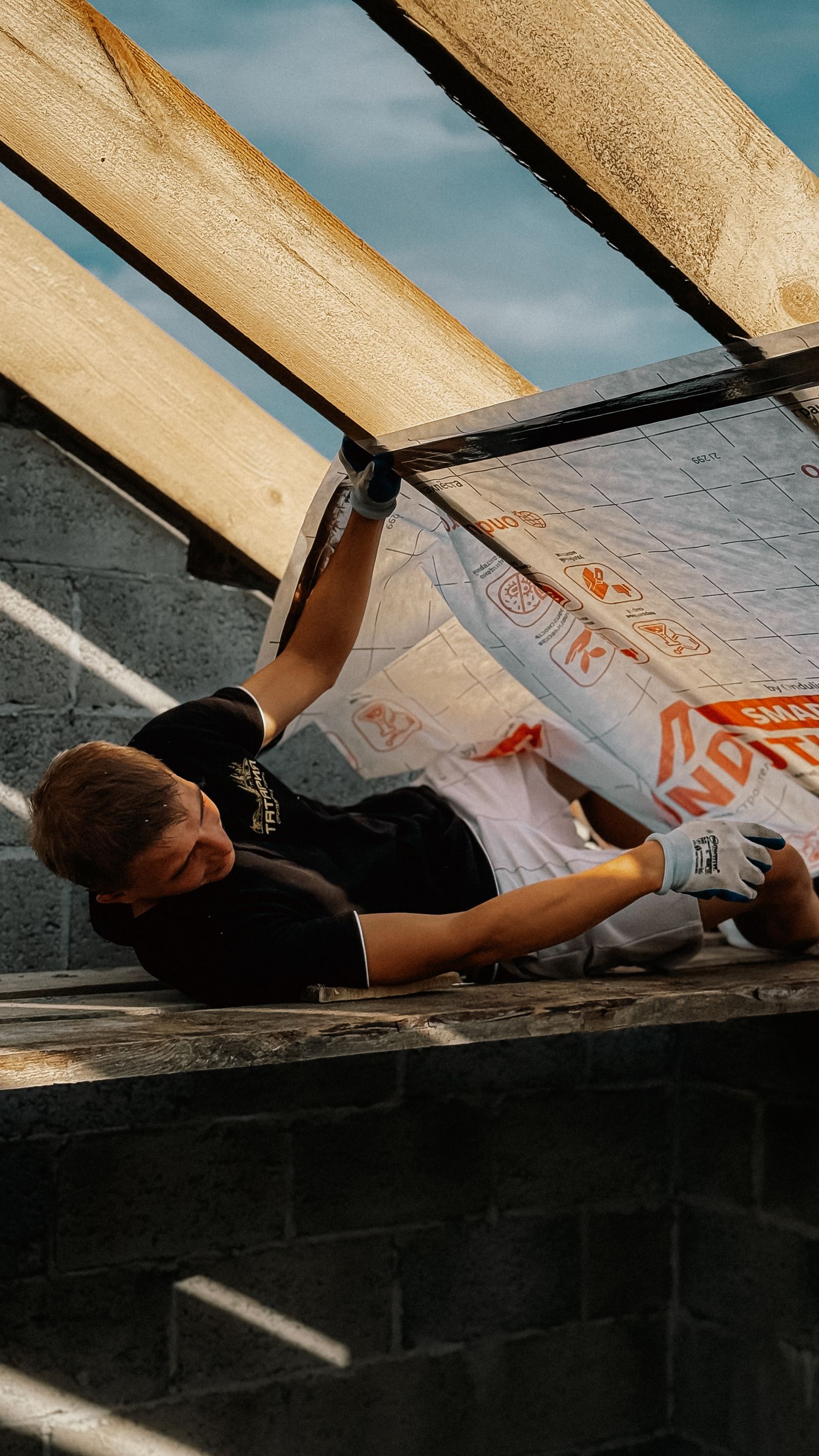 Construction worker installing roof insulation