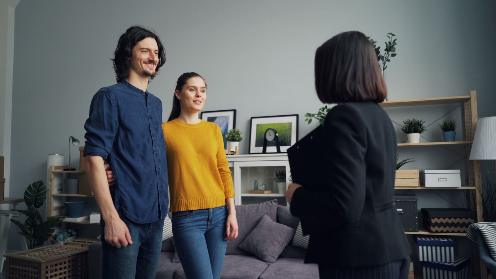 Smiling couple standing with real estate agent