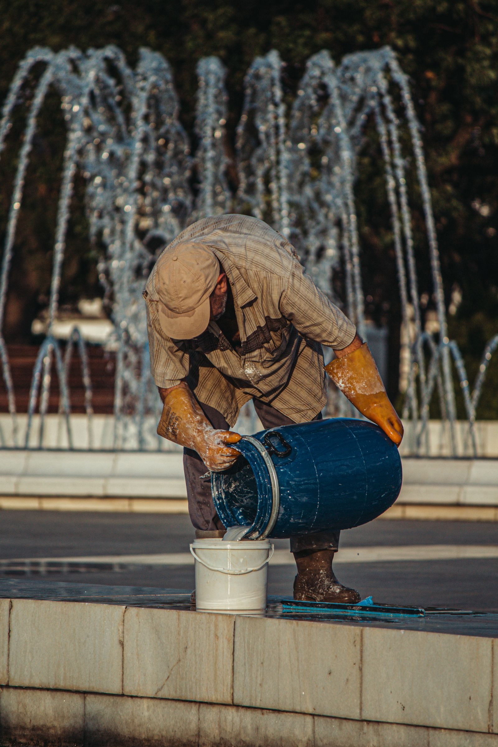 Man in rubber gloves cleaning a fountain in Baku, Azerbaijan