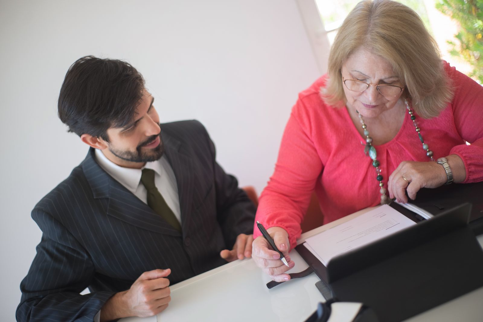Notary signing documents with client