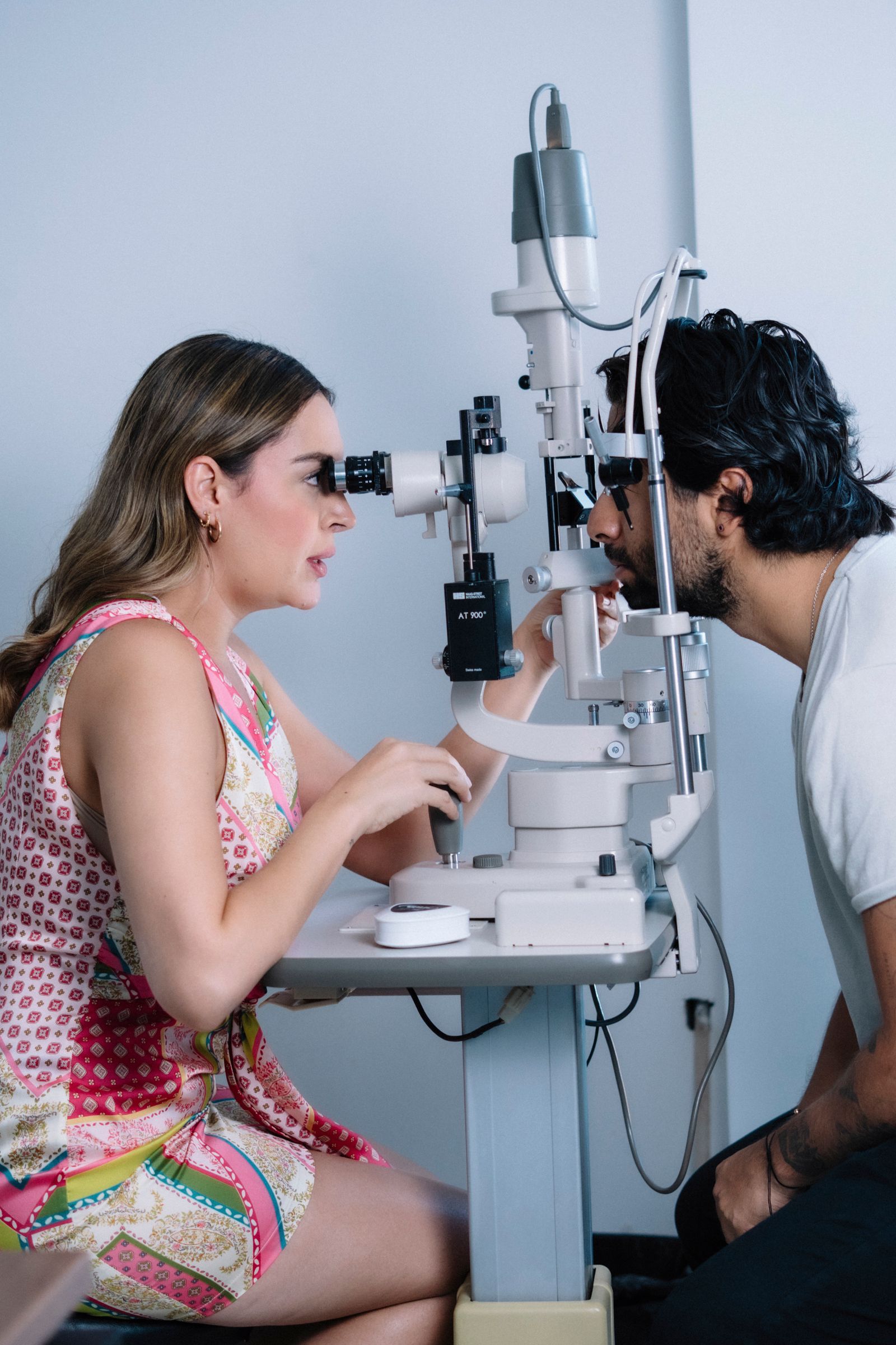 Optometrist examining patient with eye equipment