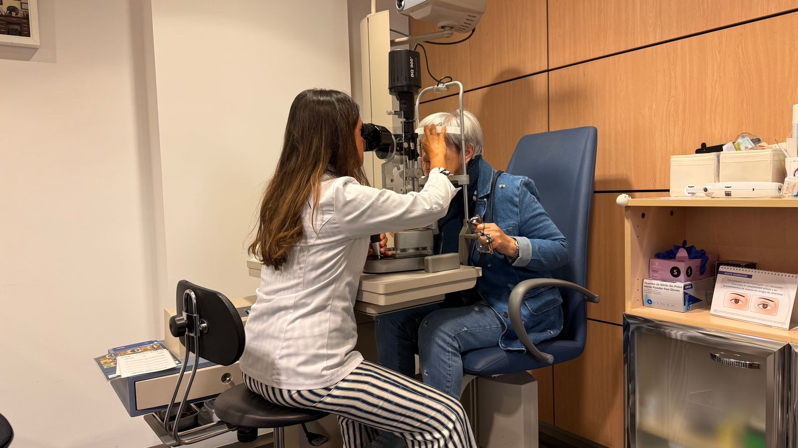 Optometrist examining patient with slit lamp