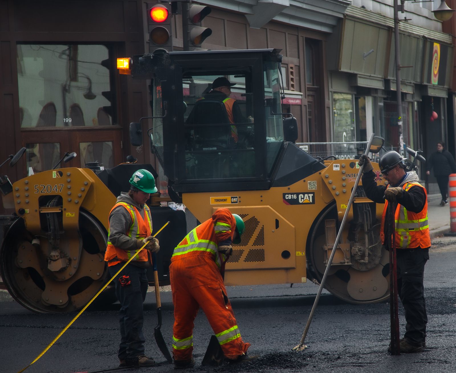 Workers and road roller on street