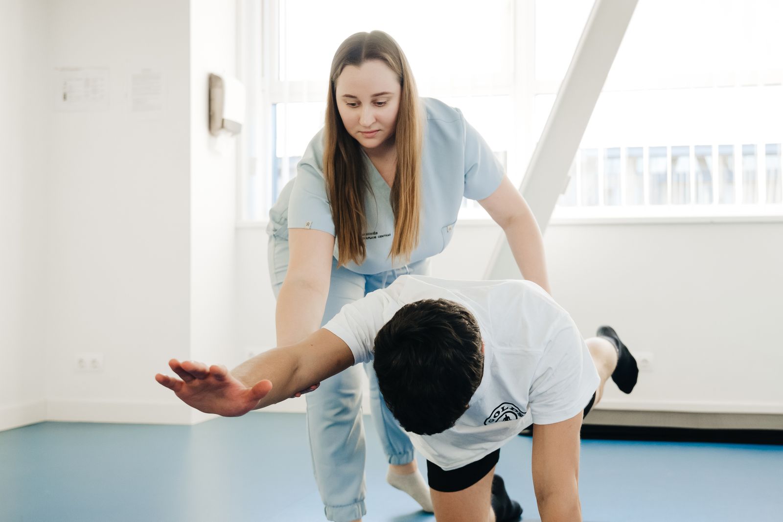 Physiotherapist with exercising man