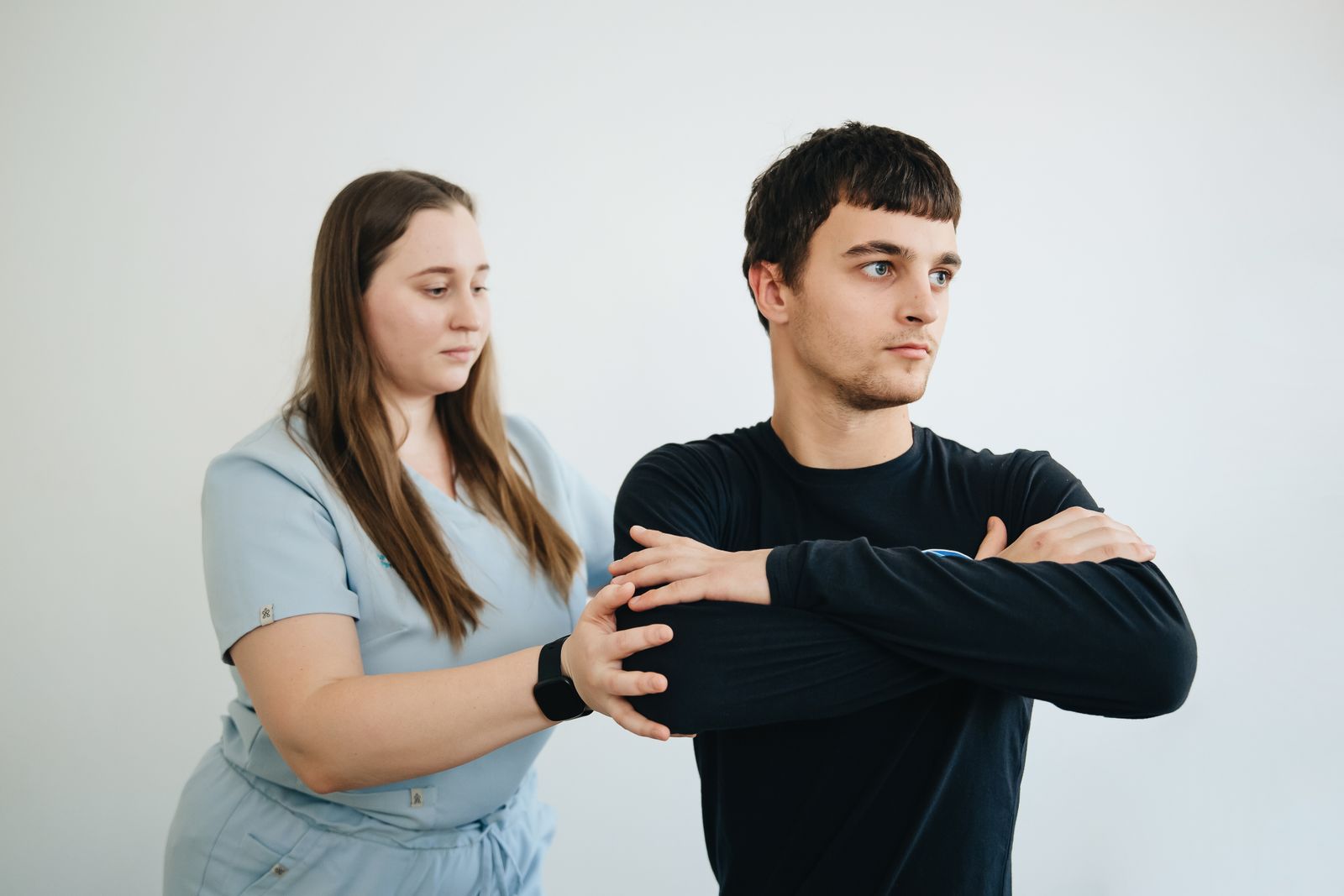Physiotherapist massaging arms of patient