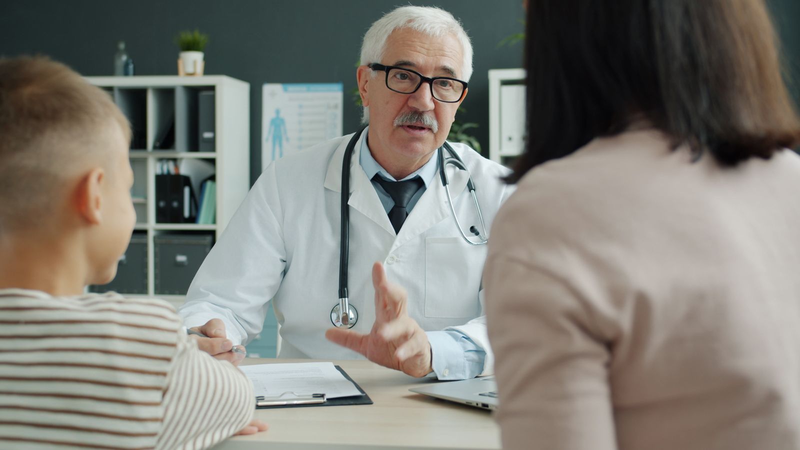 Doctor consults family in medical office