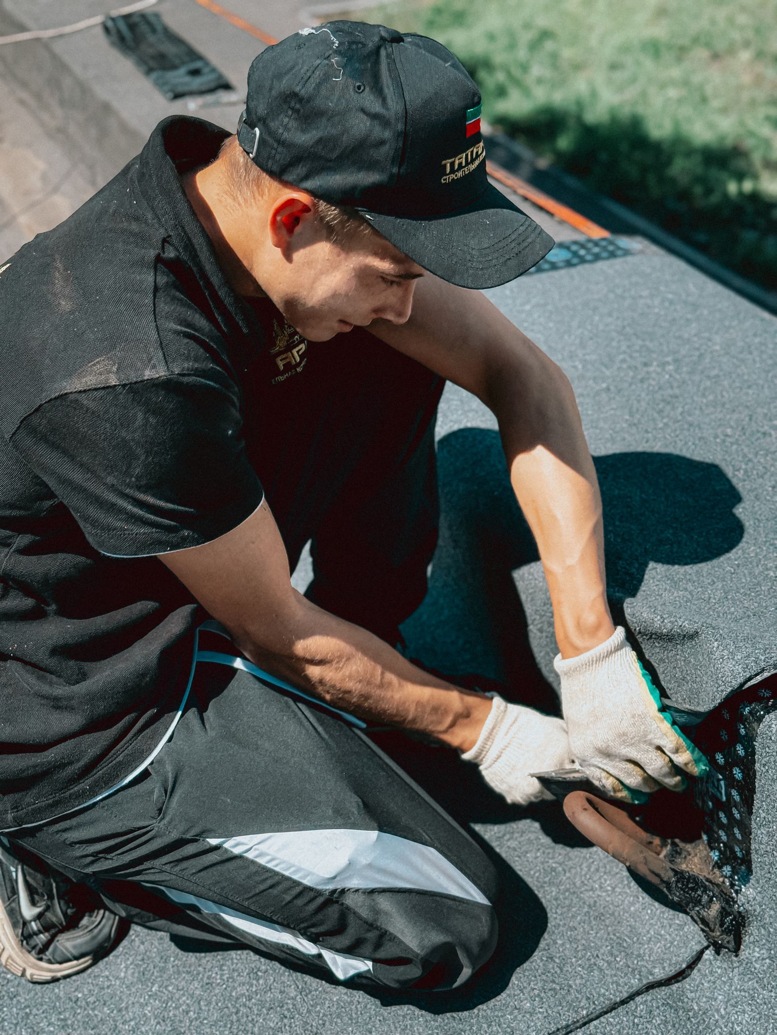 Roofer applying waterproof membrane on roof