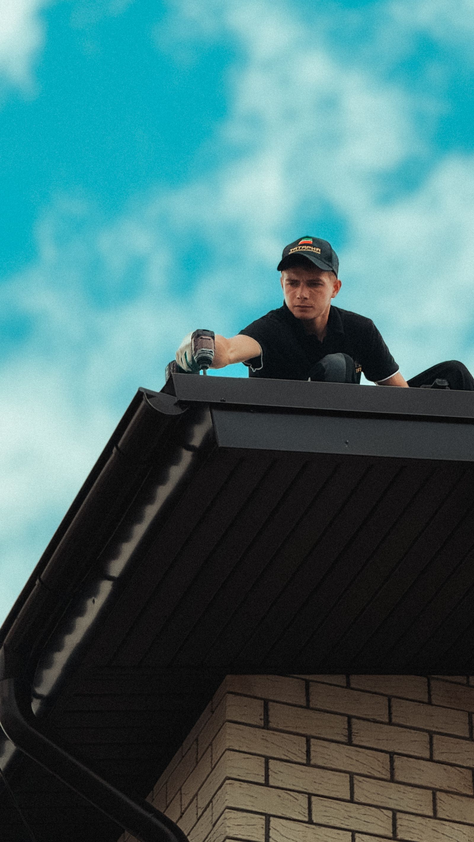 Roofer working on house roof against clear sky