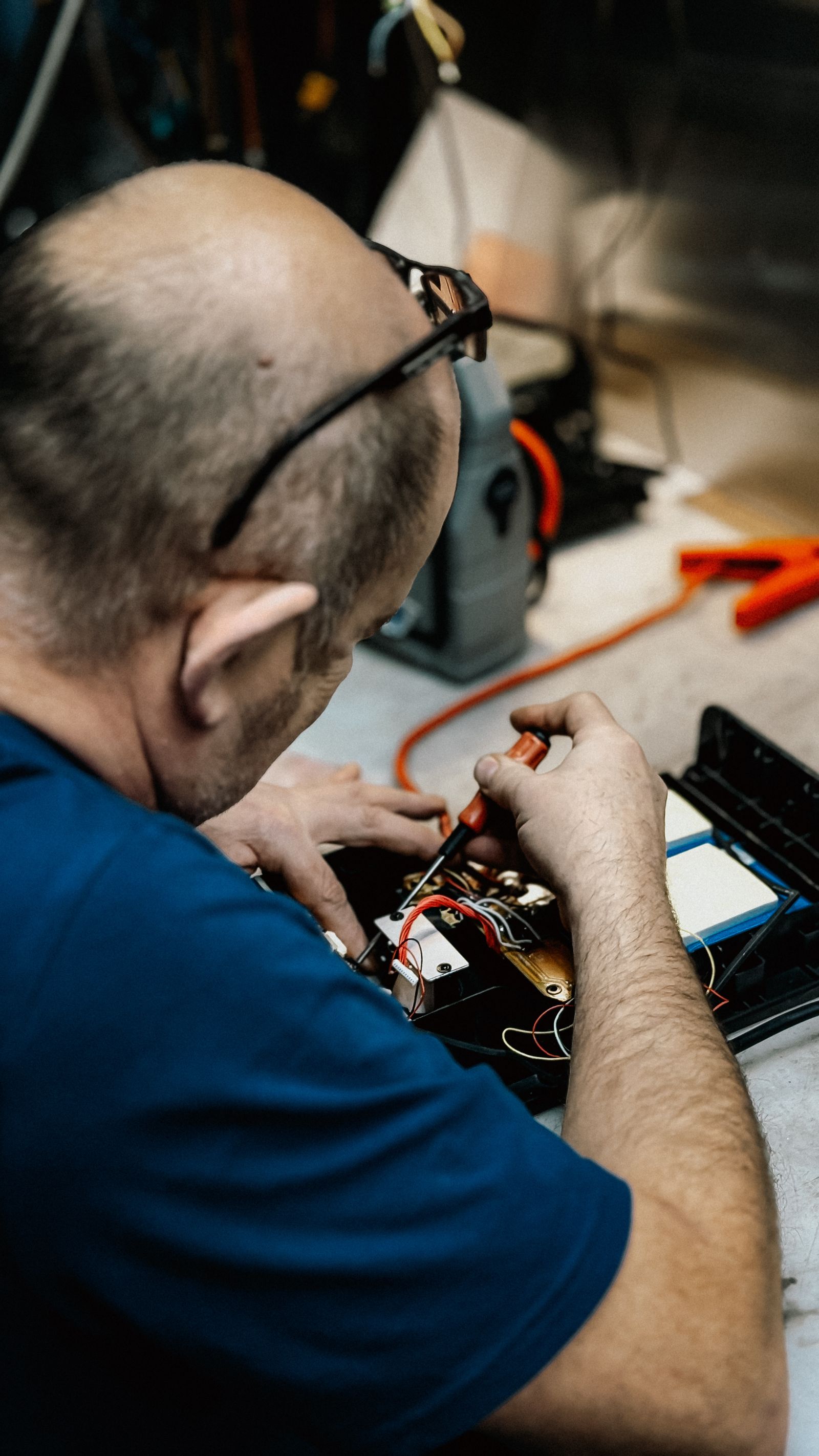 Man skillfully repairing electronic device indoors