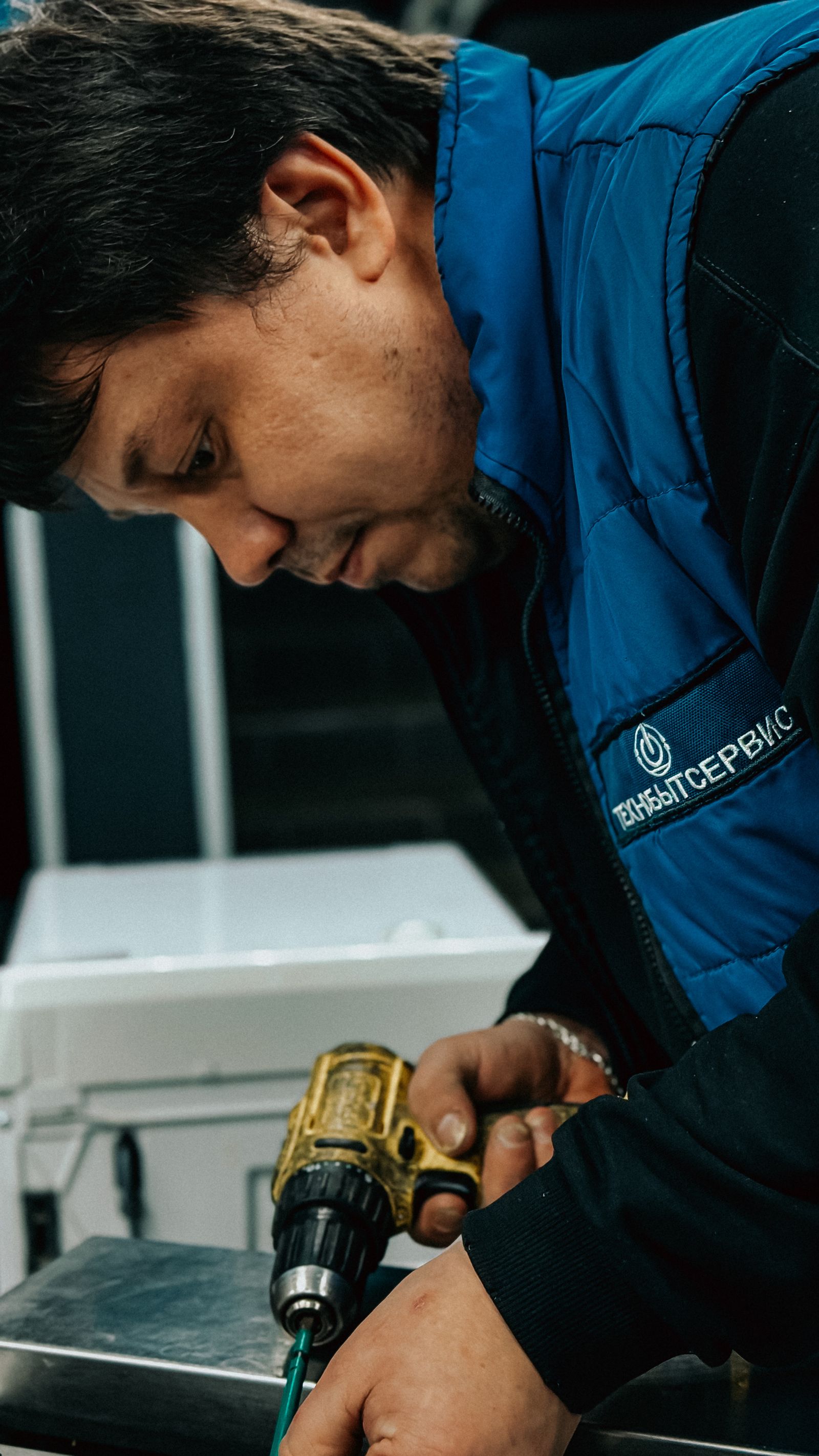 Focused technician working with power drill
