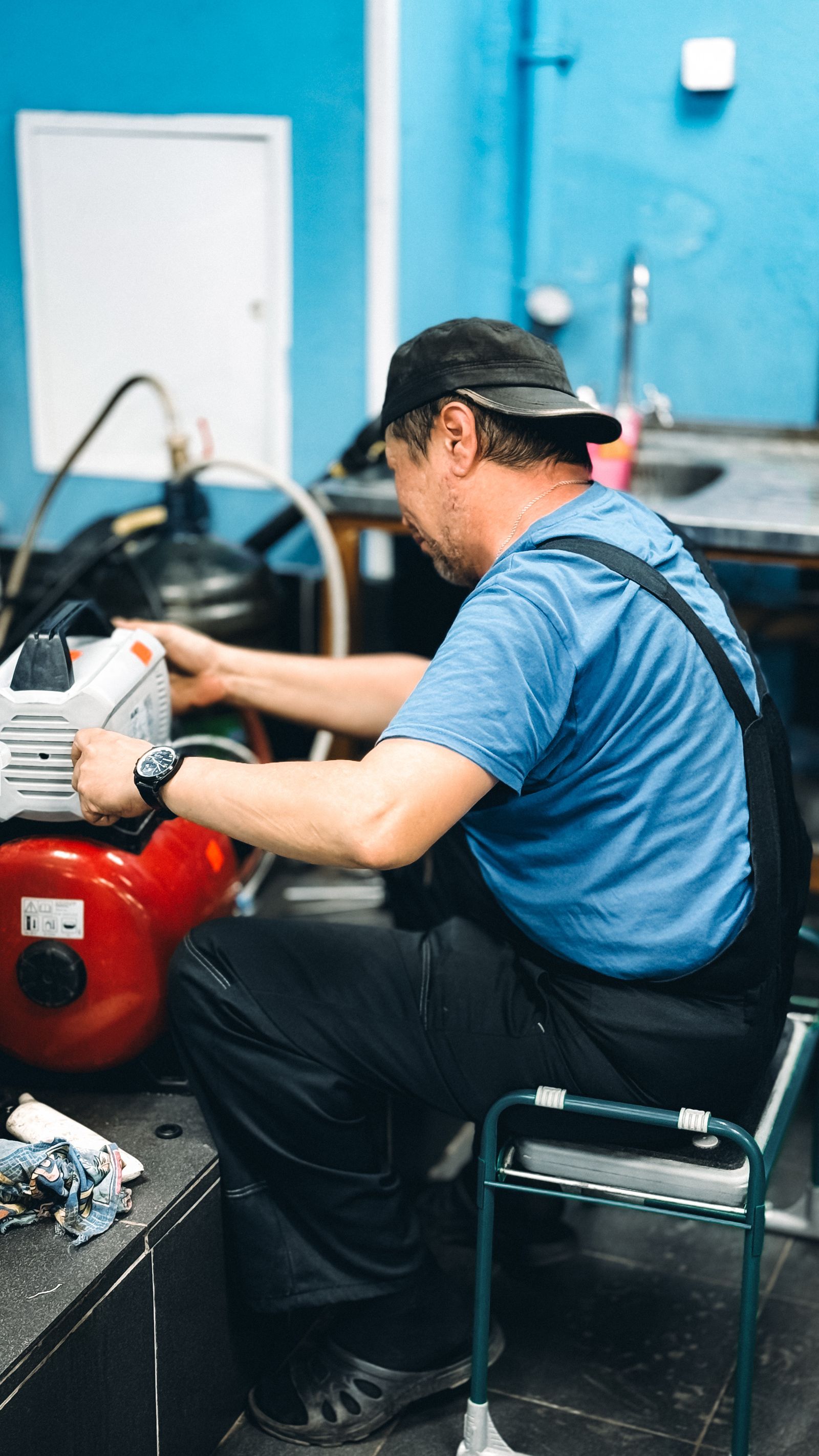 Repairman fixing machine in workshop interior