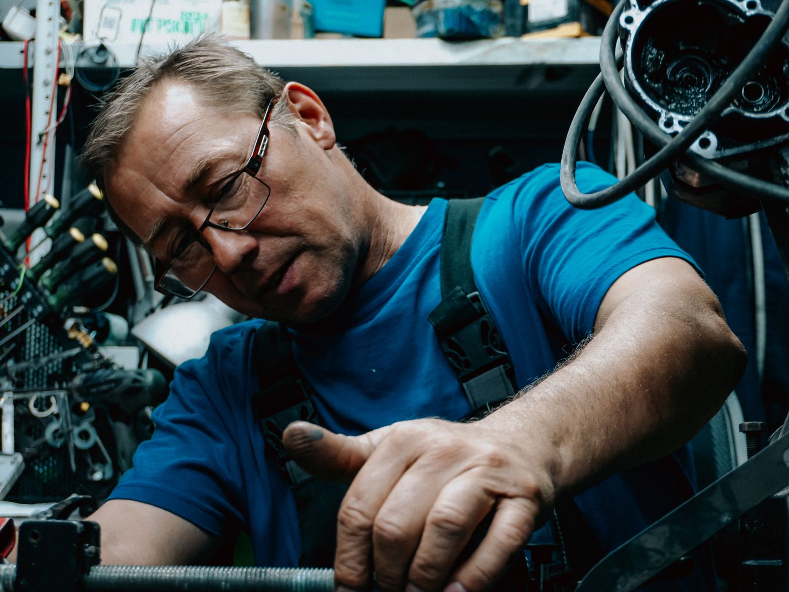 Skilled mechanic fixing engine in workshop