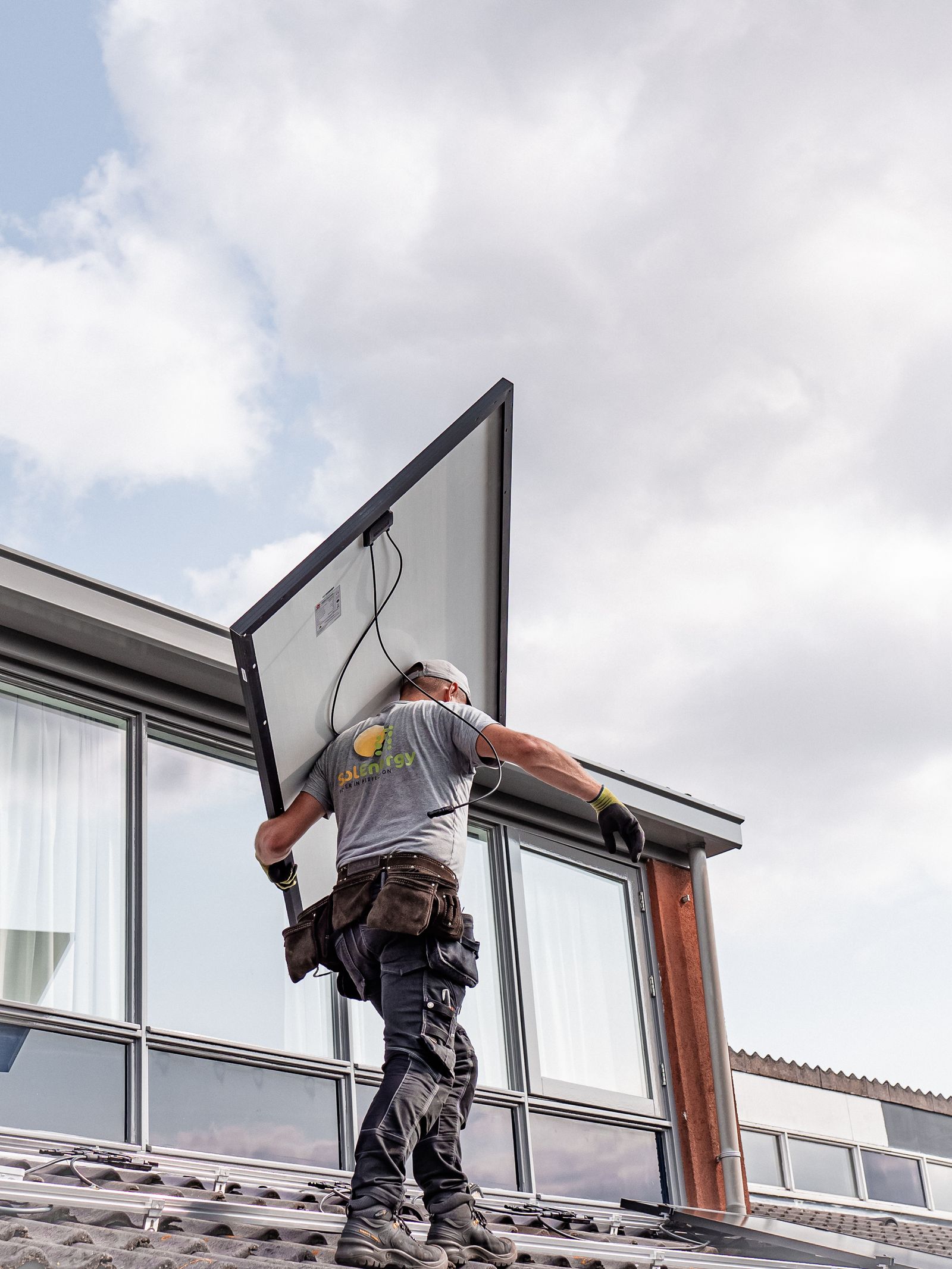 Technician installing solar panel on rooftop