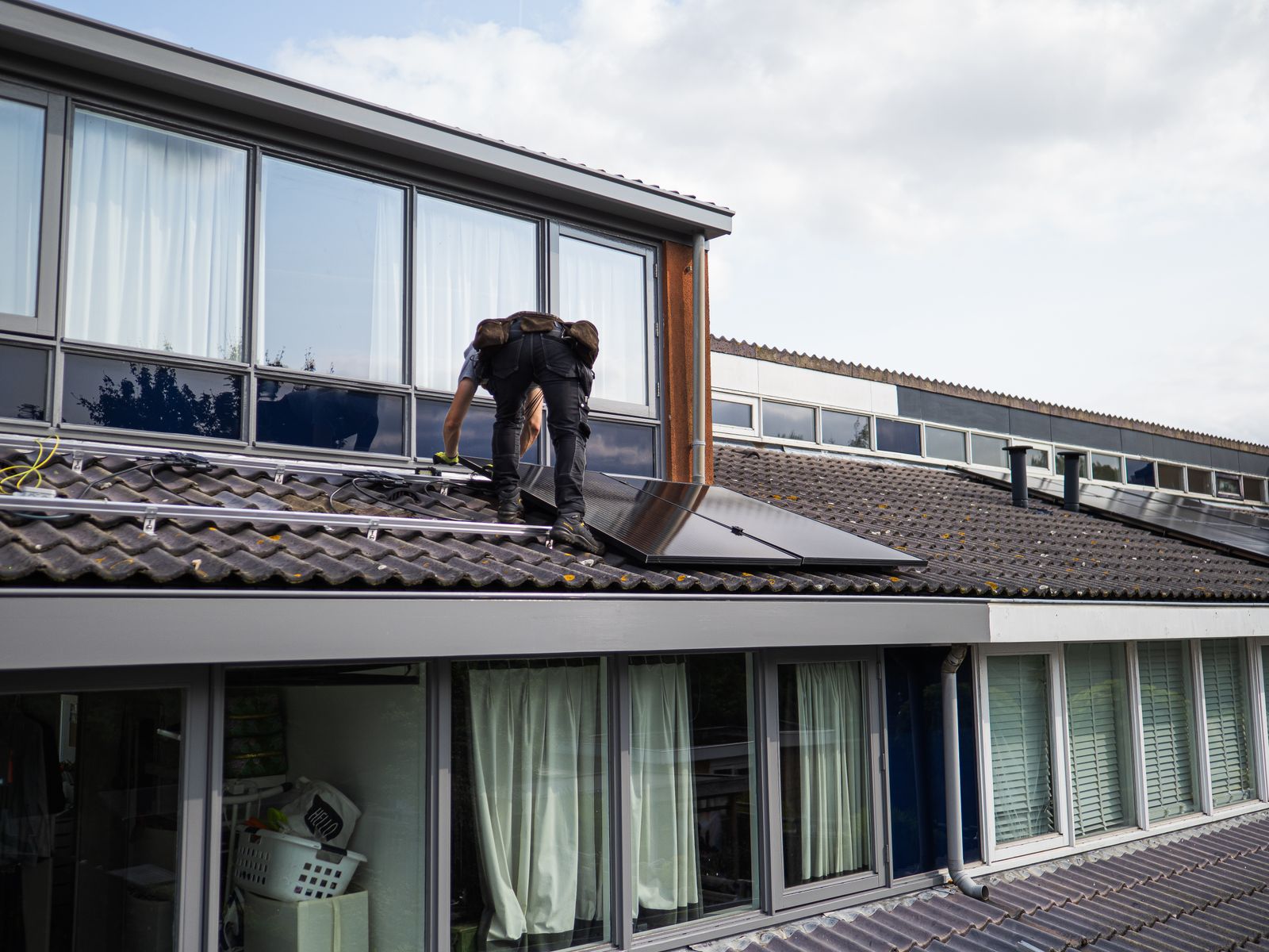 Technician installing solar panels on rooftop