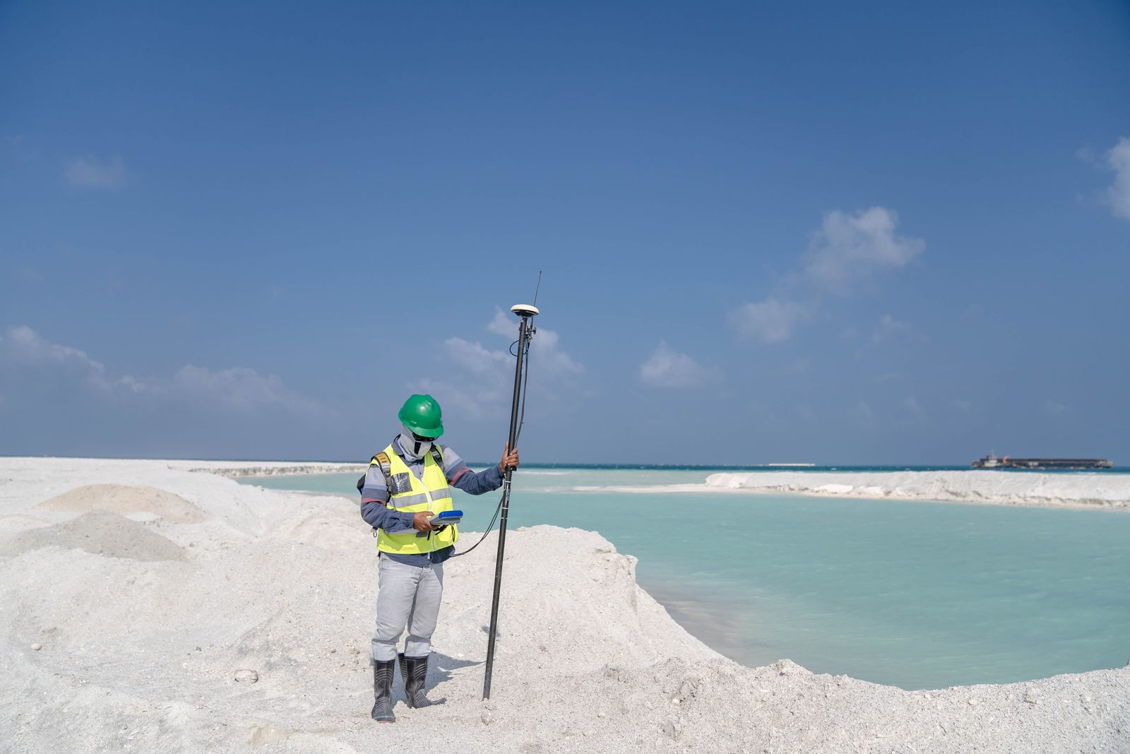 Man standing with measurement device by lake