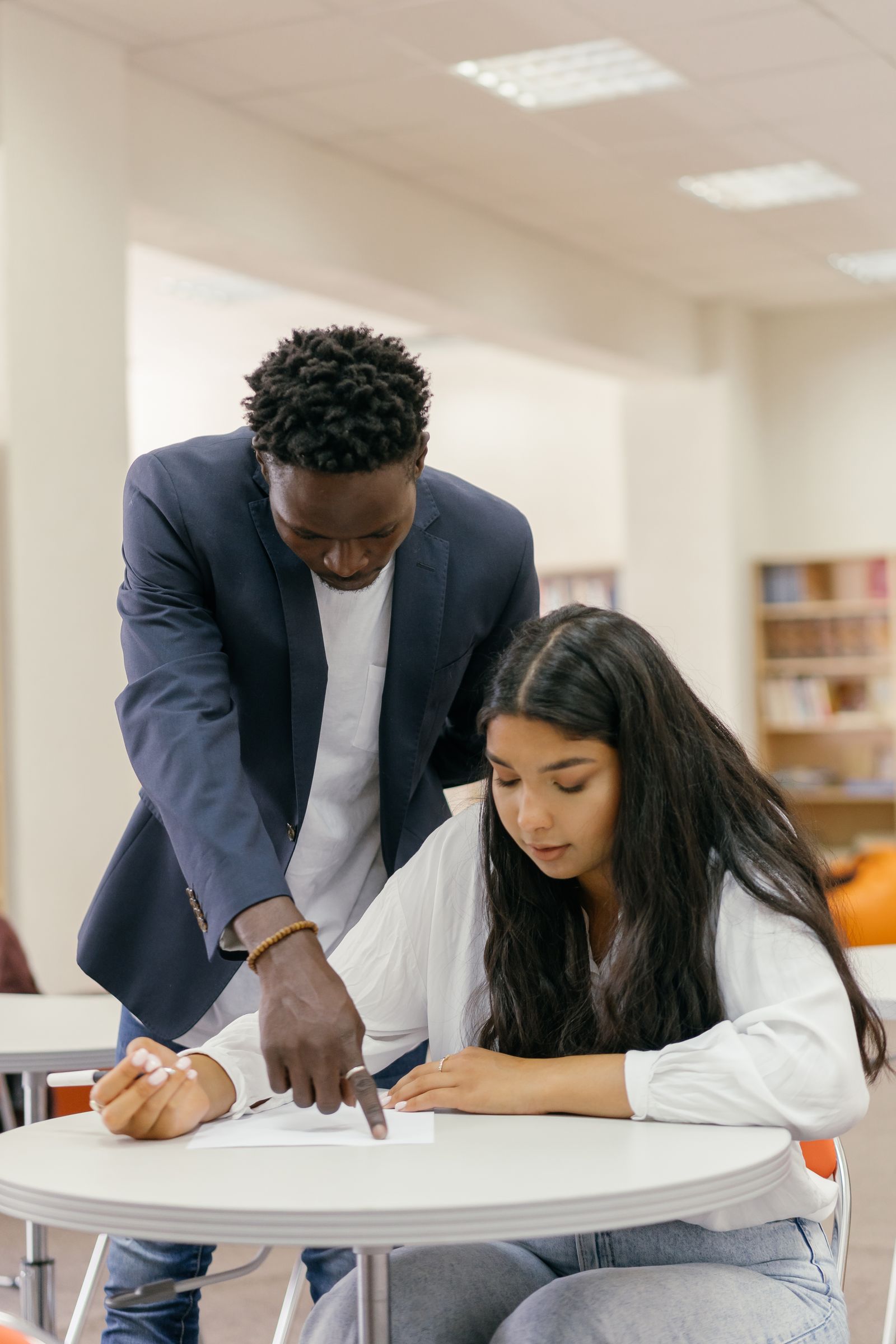 Tutor teaching student at table