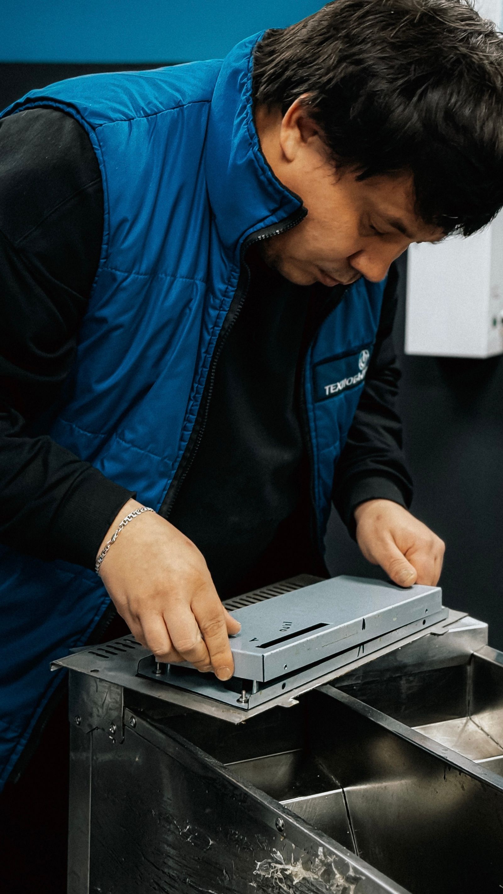 Technician installing hardware in industrial setting