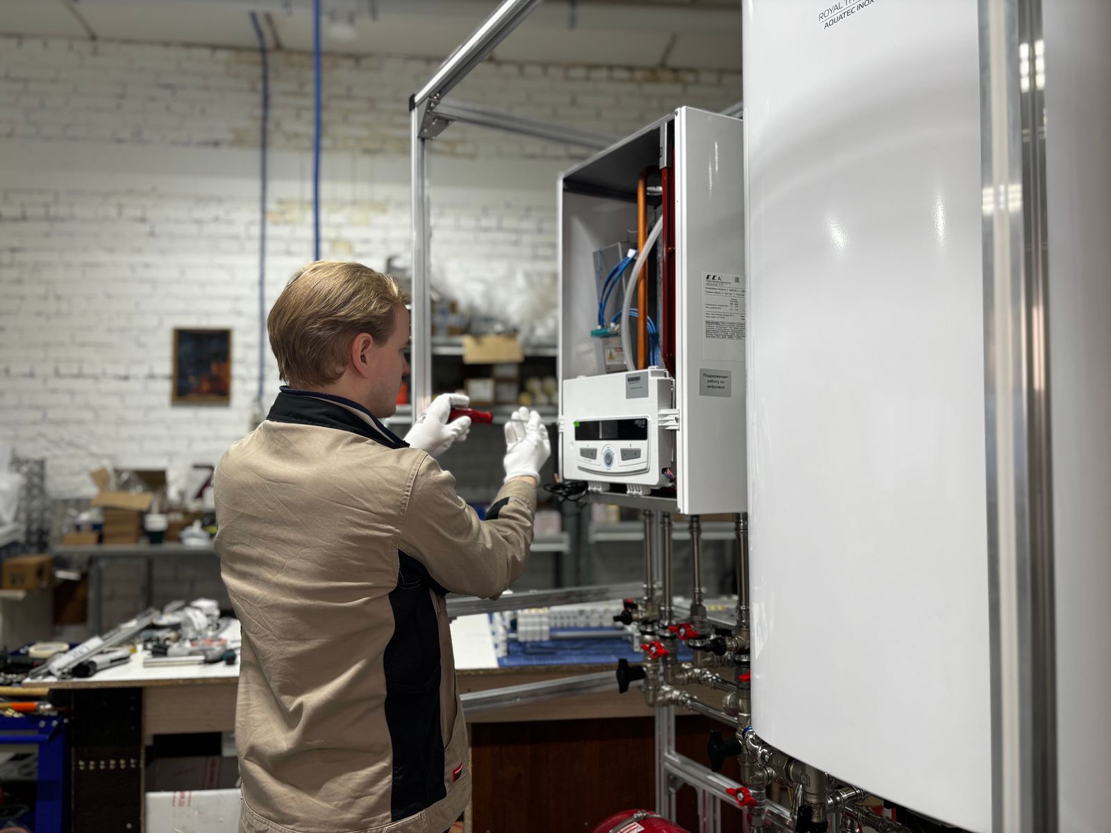 Technician maintaining heating system in workshop