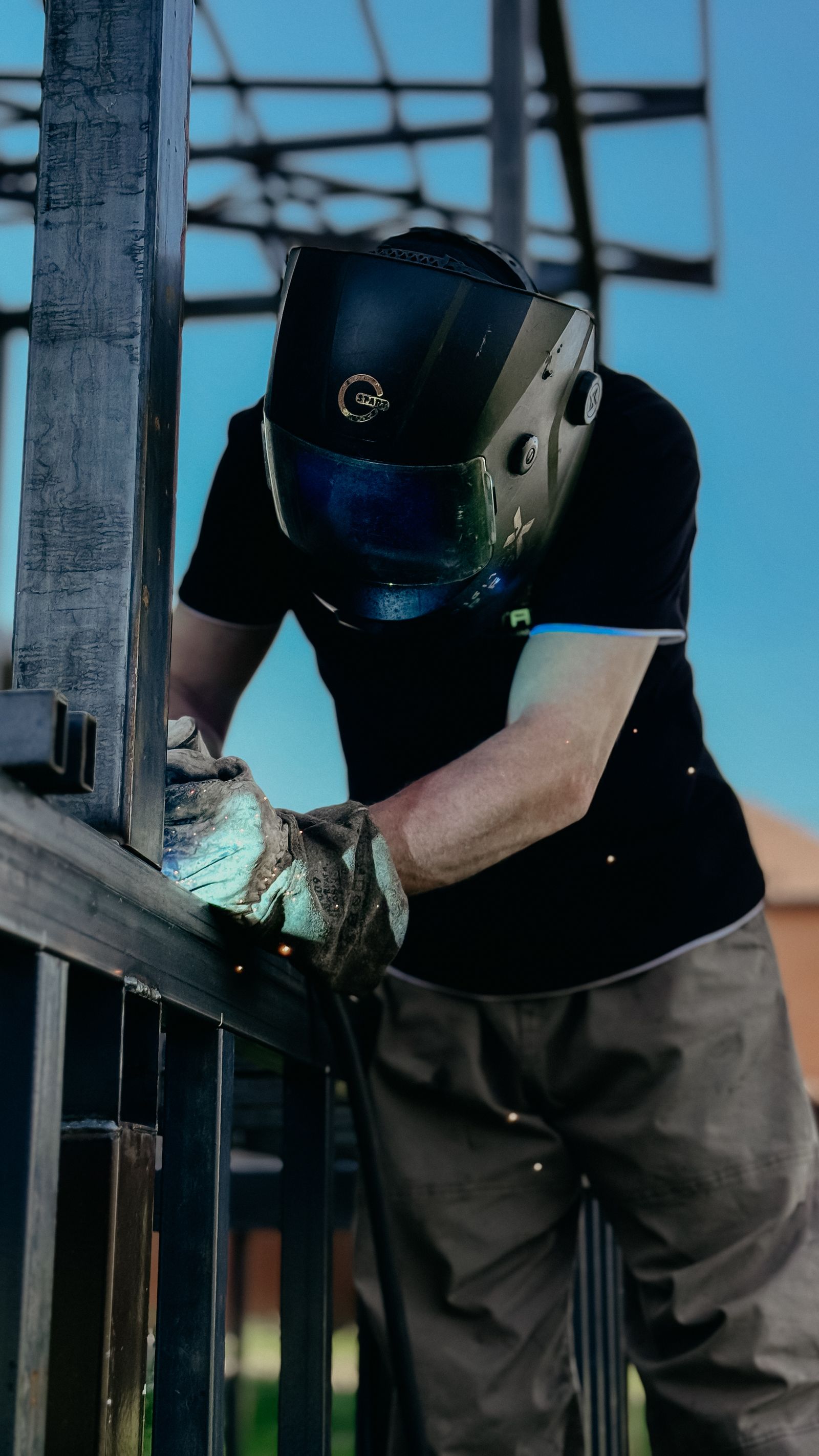 Welder focused on metalwork outdoors